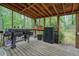 Covered patio showcasing a grill, wood plank flooring, and open views of the backyard at 408 Walnut Dr, Woodstock, GA 30189