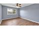 This bedroom features wood-look flooring, a ceiling fan, and a window with blinds at 6851 Roswell Rd # C7, Atlanta, GA 30328