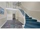 Elegant foyer featuring a chandelier, staircase with blue carpet, and a tile floor at 6851 Roswell Rd # C7, Atlanta, GA 30328