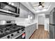 Modern kitchen featuring stainless steel appliances, gray cabinets, sleek countertops, and ample natural light from a ceiling fan at 6851 Roswell Rd # C7, Atlanta, GA 30328