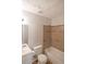 Well-lit bathroom with a tiled shower-tub combination, white vanity, toilet, and neutral-toned walls at 8449 Kendrick Rd, Jonesboro, GA 30238