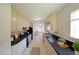 Galley kitchen featuring granite countertops, ample cabinetry, modern appliances, and tiled flooring at 8449 Kendrick Rd, Jonesboro, GA 30238