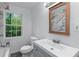 Bathroom with vanity, framed mirror, new toilet, and window at 1322 Thurgood Sw St, Atlanta, GA 30314