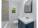 Bathroom with a white sink and a blue vanity and gray tiled walls at 1322 Thurgood Sw St, Atlanta, GA 30314