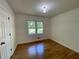 Bedroom with hardwood flooring, natural light from window, and closet door at 2682 Pineland Ave, Atlanta, GA 30340
