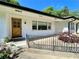 Close-up of a charming home featuring a natural wood front door and black railings on a small front porch at 2682 Pineland Ave, Atlanta, GA 30340