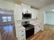 Modern kitchen featuring stainless steel appliances, white cabinets, and quartz countertops, open to the living area at 2682 Pineland Ave, Atlanta, GA 30340