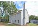 Back of the home featuring gray siding, chimney, and a quaint patio at 496 Charleston Pl, Villa Rica, GA 30180