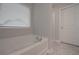 Bathroom featuring a white bathtub, window with blinds, and a white door at 496 Charleston Pl, Villa Rica, GA 30180