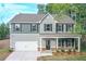 New two-story home with gray siding, black shutters, front porch, and a two-car garage at 496 Charleston Pl, Villa Rica, GA 30180