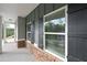 Exterior detail view of a home's covered front porch with stone accents and black shutters at 496 Charleston Pl, Villa Rica, GA 30180