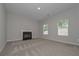 Spacious carpeted living room features a modern fireplace and two bright, window views at 496 Charleston Pl, Villa Rica, GA 30180