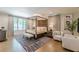 This spacious main bedroom features a four-post bed, hardwood floors, sitting area, and plenty of natural light at 1272 N Highland Ne Ave, Atlanta, GA 30306