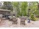 This home's patio boasts a dining table, comfortable seating, a built-in grill, and beautiful landscaping for outdoor living at 1272 N Highland Ne Ave, Atlanta, GA 30306