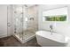 Elegant bathroom showcasing a freestanding tub, separate glass-enclosed shower, and a bright window at 2641 Drew Valley Ne Rd, Brookhaven, GA 30319