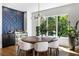 Elegant dining area with statement lighting, accent wall and lush backyard views at 2641 Drew Valley Ne Rd, Brookhaven, GA 30319