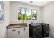 Modern laundry room featuring a large window with natural light and black stainless steel appliances at 2641 Drew Valley Ne Rd, Brookhaven, GA 30319