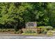 Stone sign for The River West Condominiums surrounded by lush greenery and colorful flowers at 4246 River Green Nw Dr # 202, Atlanta, GA 30327