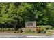 Landscaped entrance to The River West Condominium with stone signage and colorful flowerbeds at 4246 River Green Nw Dr # 202, Atlanta, GA 30327