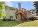 Exterior showcasing a two-story home with a deck, stairs, and lush green lawn at 4855 Regency Sw Trce, Atlanta, GA 30331
