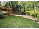 Spacious, well-manicured backyard with lush green grass, mature trees, and a partial view of the deck at 4855 Regency Sw Trce, Atlanta, GA 30331