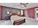 Spacious bedroom with red accent wall, ceiling fan, and two side tables with lamps at 5800 S Richland Creek Rd, Buford, GA 30518