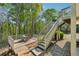 View of the back deck with dining table, chairs, and stairs leading to the upper level of the home at 6565 Scottsfield Trce, Cumming, GA 30028
