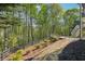 Scenic backyard with deck, stone path, and lush greenery offers serene outdoor living at 6565 Scottsfield Trce, Cumming, GA 30028