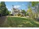 Expansive backyard with a well-maintained lawn, wooden deck, and lush greenery, offering a serene outdoor space at 6565 Scottsfield Trce, Cumming, GA 30028