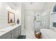 Bright bathroom with double vanity, soaking tub, glass shower, and natural light at 6565 Scottsfield Trce, Cumming, GA 30028
