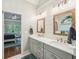Bathroom with double sink vanity, wood-framed mirrors, and wood detail; bedroom visible through doorway at 6565 Scottsfield Trce, Cumming, GA 30028