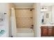 Bathroom features a tiled shower with a tub and a view of the vanity at 6565 Scottsfield Trce, Cumming, GA 30028