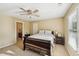 Neutral bedroom featuring a ceiling fan, a dark sleigh bed, and a window at 6565 Scottsfield Trce, Cumming, GA 30028
