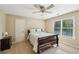 Comfortable bedroom featuring a ceiling fan, a dark sleigh bed, and a window at 6565 Scottsfield Trce, Cumming, GA 30028