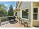 Relax on the deck featuring a grill and dining area with views of the trees and blue sky at 6565 Scottsfield Trce, Cumming, GA 30028