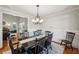 Traditional dining room with hardwood floors, a chandelier, and seamless access to the living room at 6565 Scottsfield Trce, Cumming, GA 30028