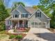 Attractive two-story home with a two-car garage, complemented by a cozy front porch adorned with colorful flowers at 6565 Scottsfield Trce, Cumming, GA 30028