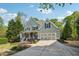 Beautifully designed two-story home with a spacious two-car garage and a welcoming front porch with seating at 6565 Scottsfield Trce, Cumming, GA 30028