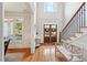 Elegant foyer with hardwood floors, a staircase, and a bench, showcasing a bright and welcoming entryway at 6565 Scottsfield Trce, Cumming, GA 30028