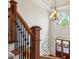 Bright foyer features hardwood floors, striking chandelier, and an elegant staircase with wood and wrought iron at 6565 Scottsfield Trce, Cumming, GA 30028