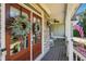 Welcoming front entrance with wooden doors adorned with wreaths, leading to a charming porch with rocking chairs at 6565 Scottsfield Trce, Cumming, GA 30028