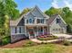 Well-manicured lawn and garden beds accentuate the stately two-story home at 6565 Scottsfield Trce, Cumming, GA 30028