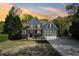Charming two-story home with manicured lawn and blooming flowers at dusk at 6565 Scottsfield Trce, Cumming, GA 30028