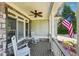 Inviting front porch with rocking chairs, perfect for relaxing, complemented by stone accents and a ceiling fan at 6565 Scottsfield Trce, Cumming, GA 30028