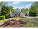 Beautifully landscaped front yard featuring vibrant flowerbeds and a lush green lawn, enhancing the home's curb appeal at 6565 Scottsfield Trce, Cumming, GA 30028