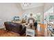 Spacious living room with hardwood floors, a stone fireplace, and comfortable seating, creating an inviting atmosphere at 6565 Scottsfield Trce, Cumming, GA 30028