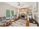 Inviting living room with stone fireplace, built-in shelving, and hardwood floors at 6565 Scottsfield Trce, Cumming, GA 30028
