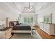 Serene main bedroom featuring a tray ceiling, natural light, and hardwood floors at 6565 Scottsfield Trce, Cumming, GA 30028