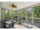 Relax on this screened porch featuring a ceiling fan and views of the surrounding trees at 6565 Scottsfield Trce, Cumming, GA 30028