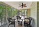 Relax on this screened porch featuring a ceiling fan and views of the surrounding trees at 6565 Scottsfield Trce, Cumming, GA 30028